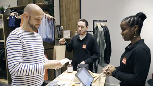 a SYVECO employee in a sales situation in a shop with students from the Apprentis d'Auteuil Foundation